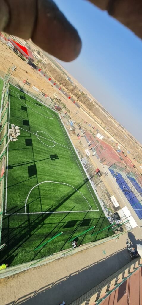 ملعب كرة قدم مكتمل بالعشب الصناعي والتخطيط من الأعلى