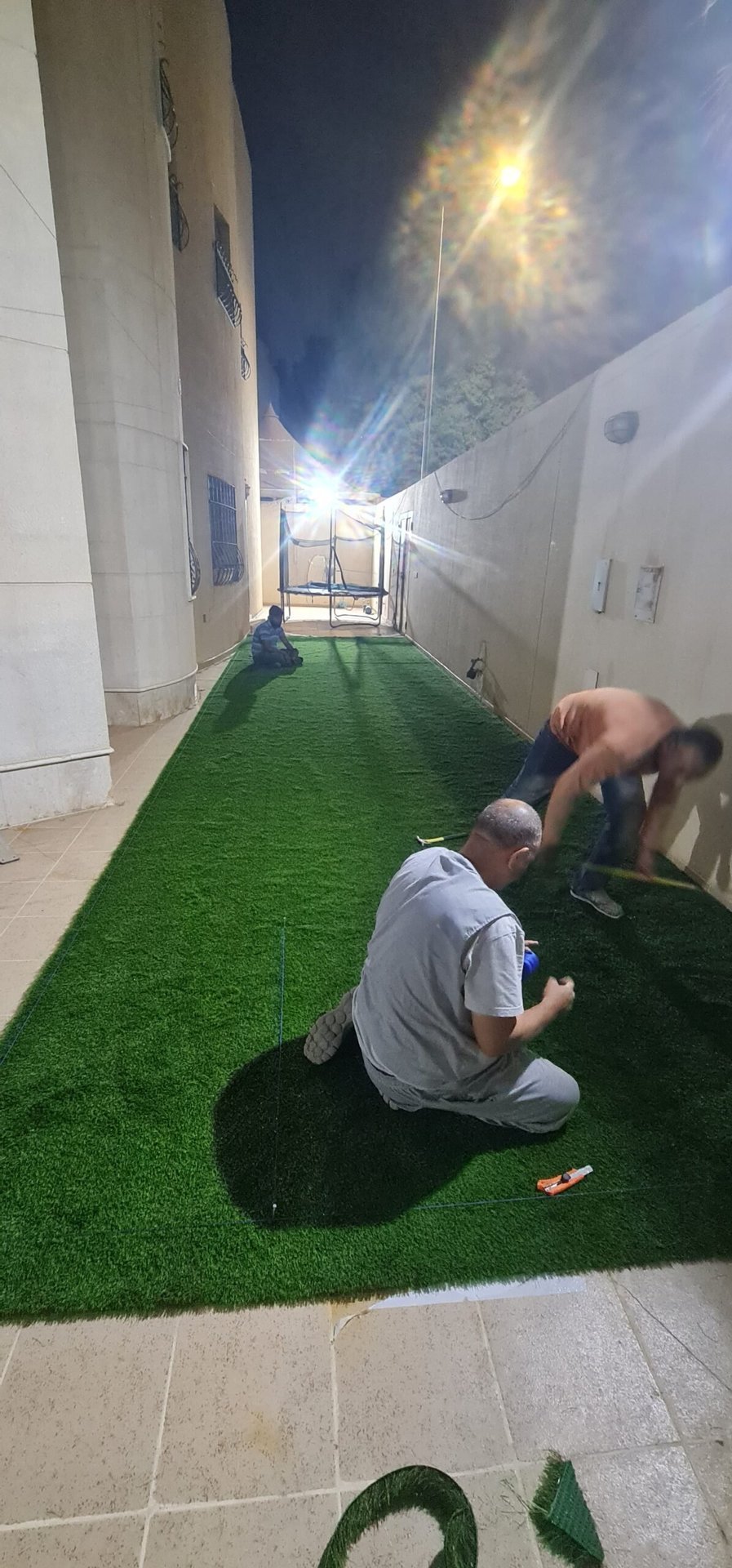 تثبيت العشب الصناعي أثناء التنفيذ ليلًا