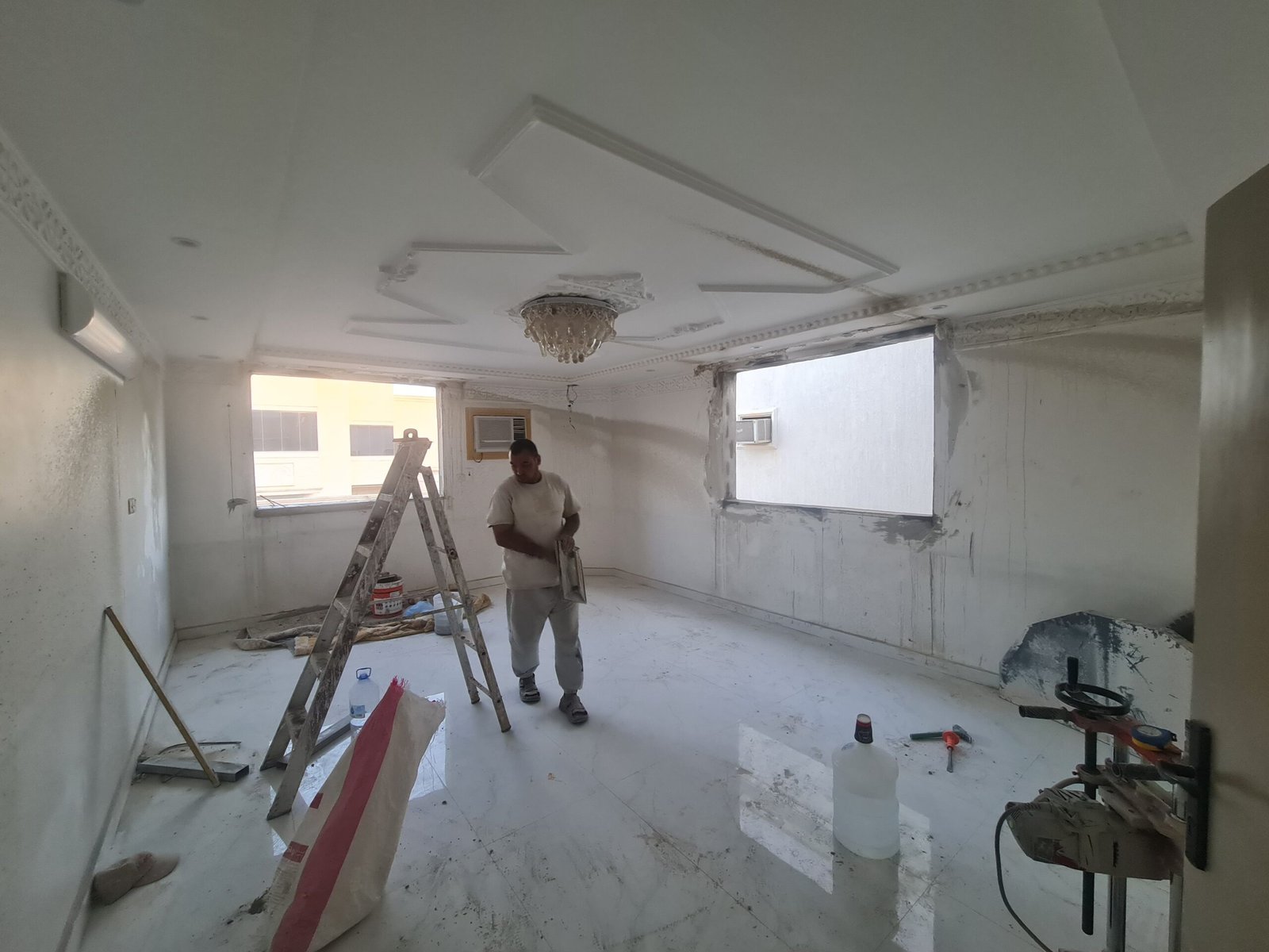 فنيان أثناء قص فتحات الشبابيك من الداخل