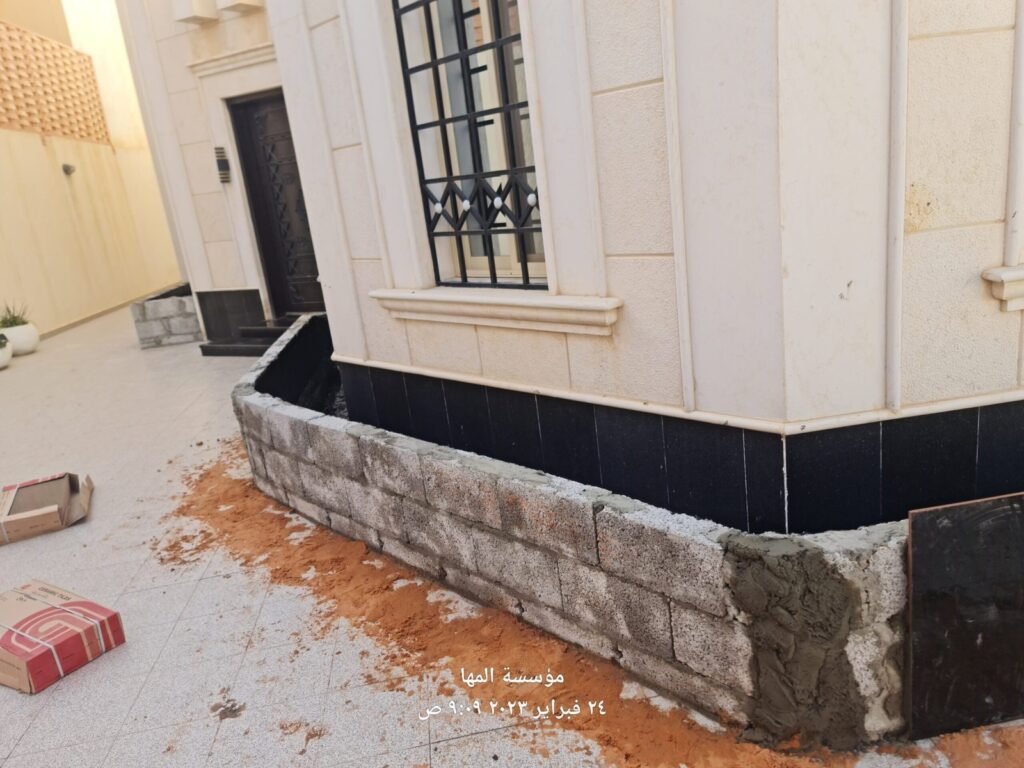 مرحلة بناء حوض زراعي إسمنتي باللياسة على واجهة فيلا قبل التغليف