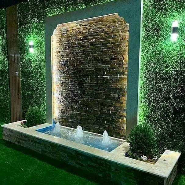 شلال جداري بنافورة وسط العشب الجداري